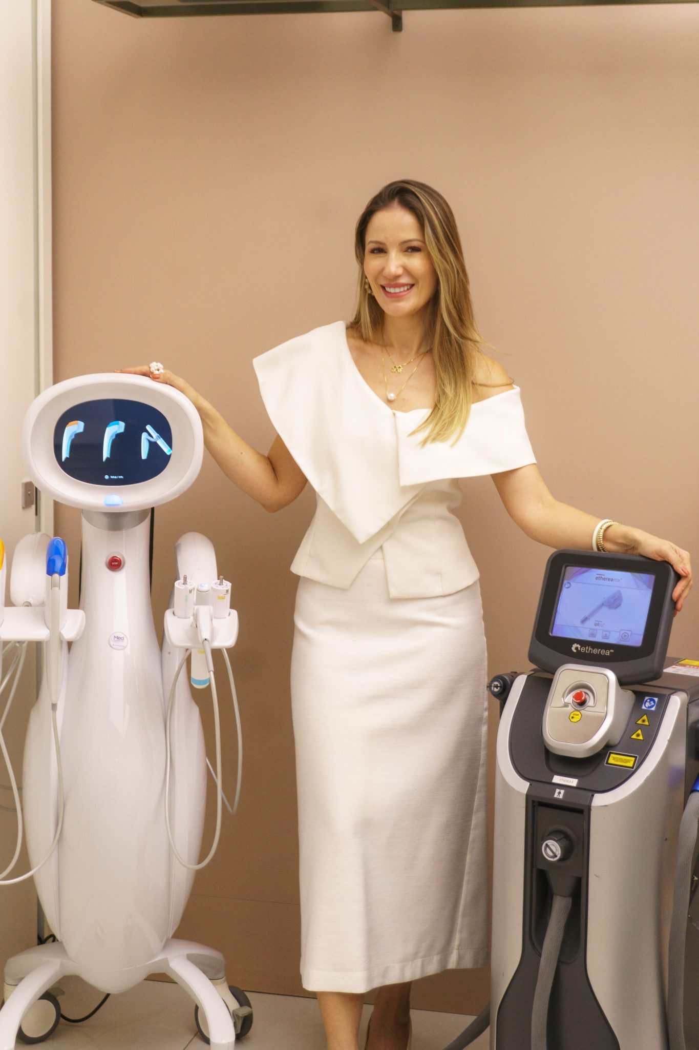 Dra. Sabrina Cunha ao lado dos aparelhos Ultraformer MPT e Laser Etherea